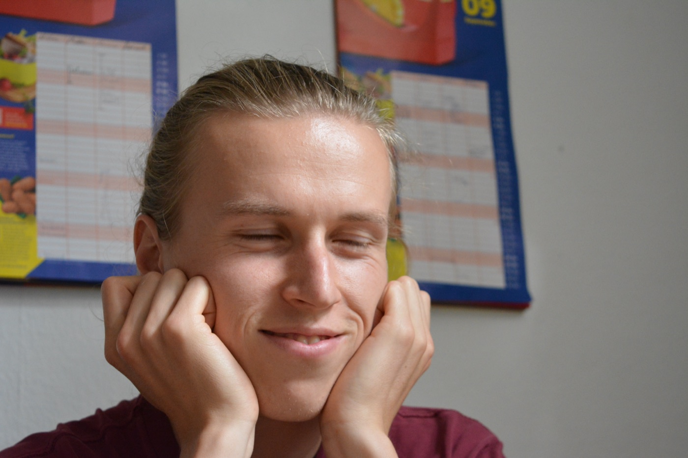 Niklas mit beiden Händen an den Wangen, Augen geschlossen